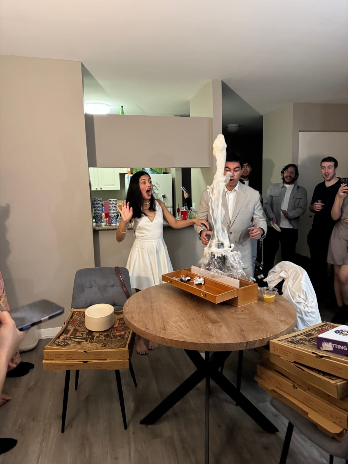 Krati and Shaan reacting to a surprise while celebrating with friends